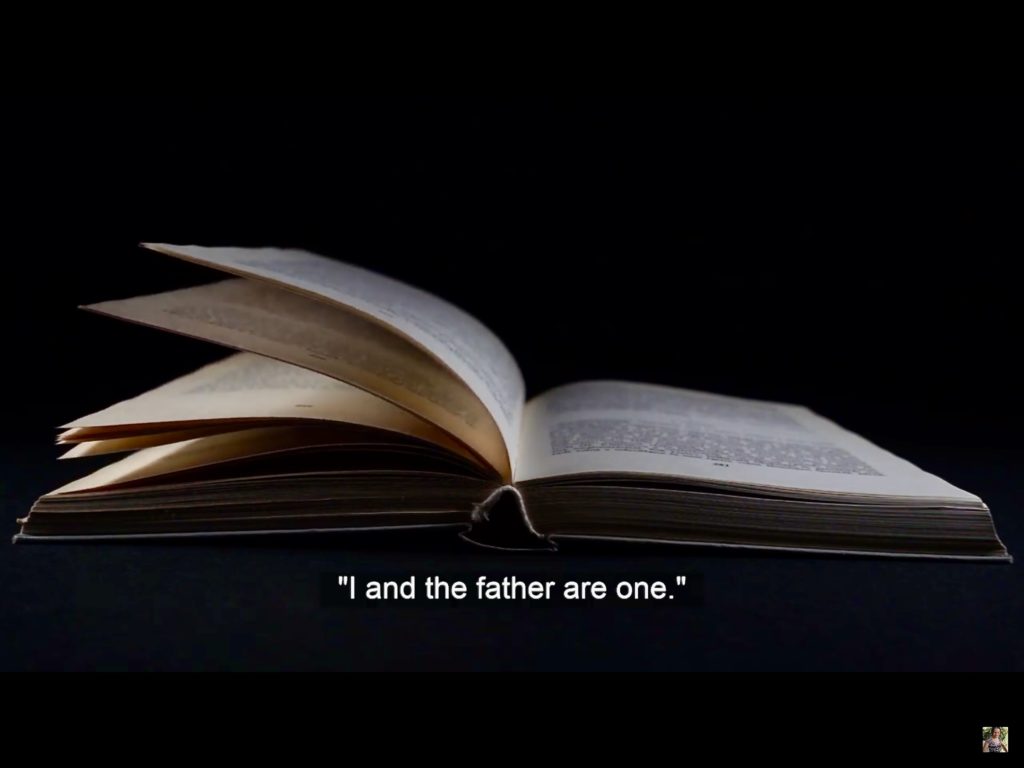 Image of an open book with a message that reads "I and the father are one" at the bottom